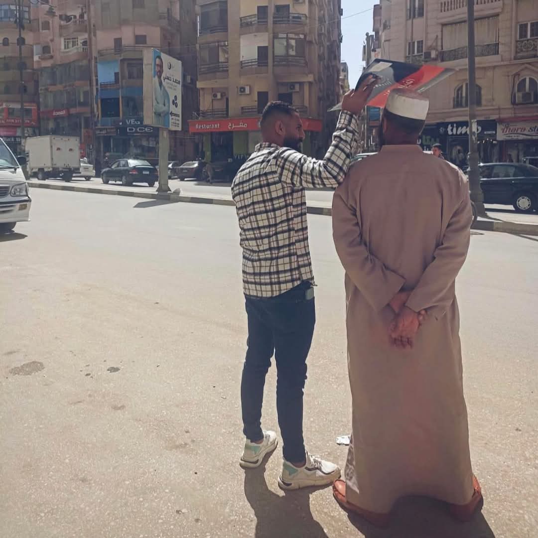 مشهد مؤثر في شوارع الفيوم.. شاب يحمي والده من الشمس