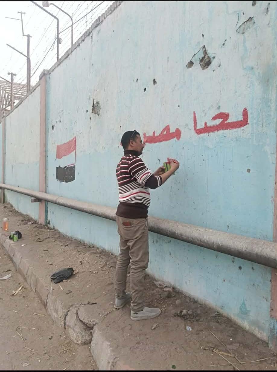 ضمن مبادرة "بإيدينا هنجملها".. رئيس قرية "هو" بقنا يزين الجدران بعلم مصر